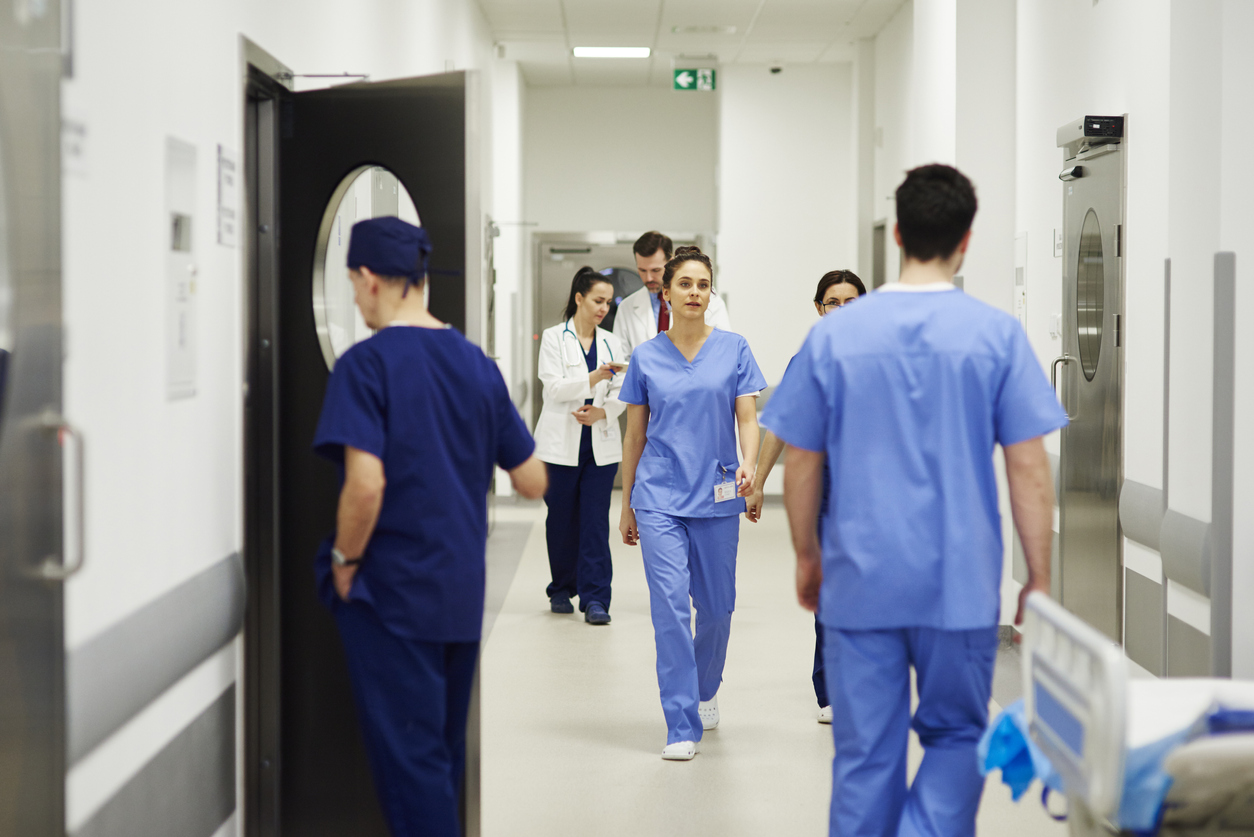 Nurses Walk up and Down a Busy Hospital Corridor.