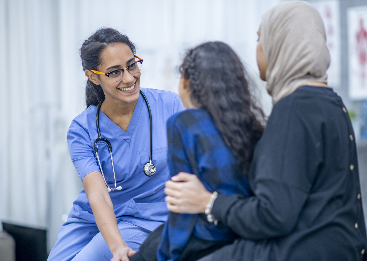 Nurse Smiling With a Child Patient and Their Parent..jpg