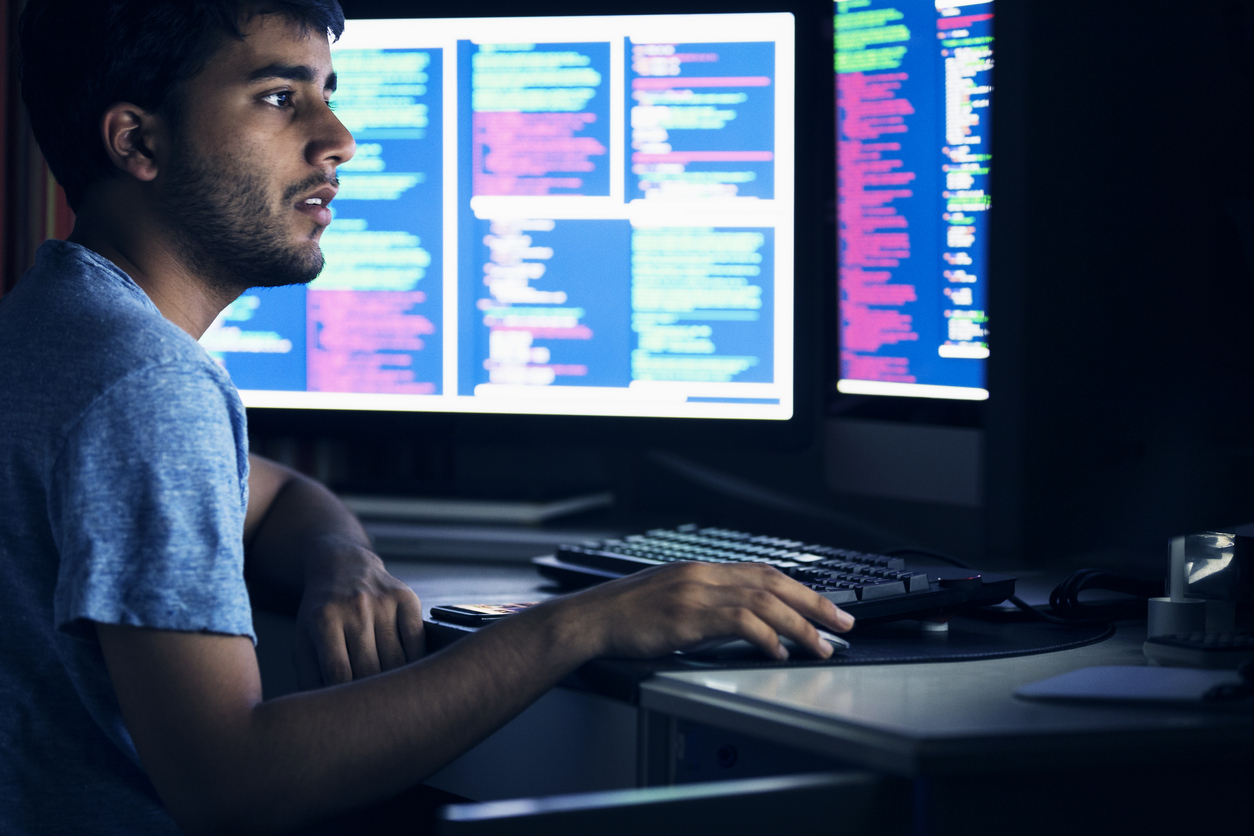 Cybersecurity Student Working on Multiple Monitors.