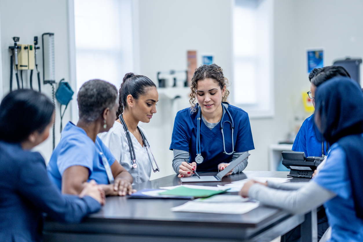 A group of nurses gathered around a conference table.