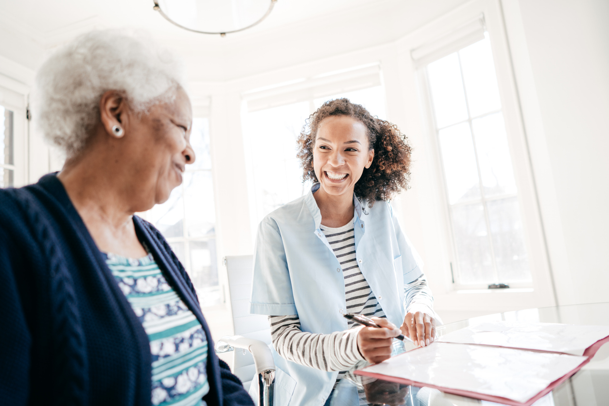 A smiling patient advocate meets with a patient.