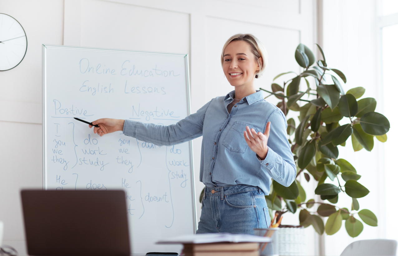 A Smiling Teacher Leading an Online English Class.