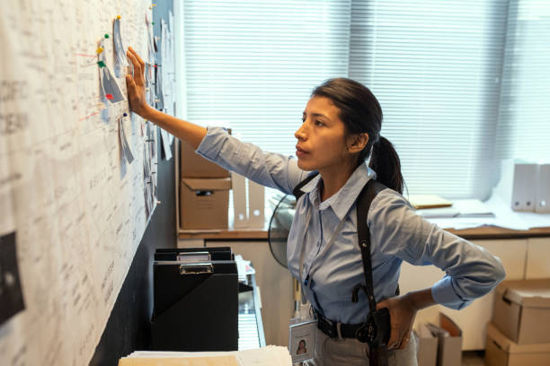 A Criminal Investigator Examines Evidence Displayed on a Bulletin Board.