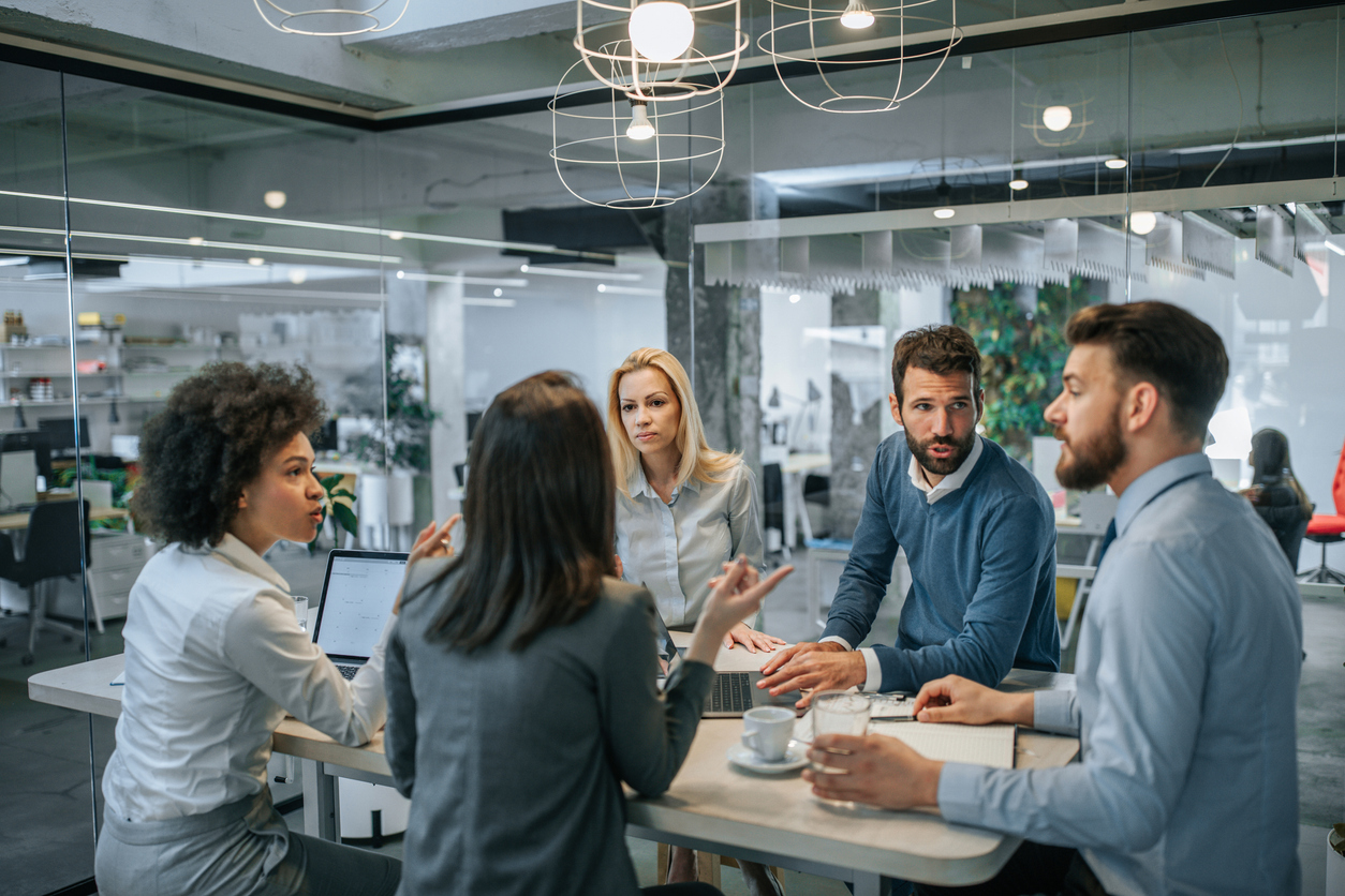 A group of co-workers meeting around a conference table.