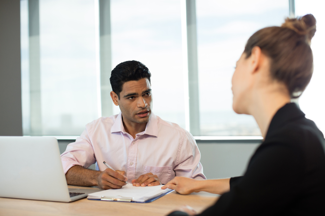 A Seated Probation Officer Meets With a Client.