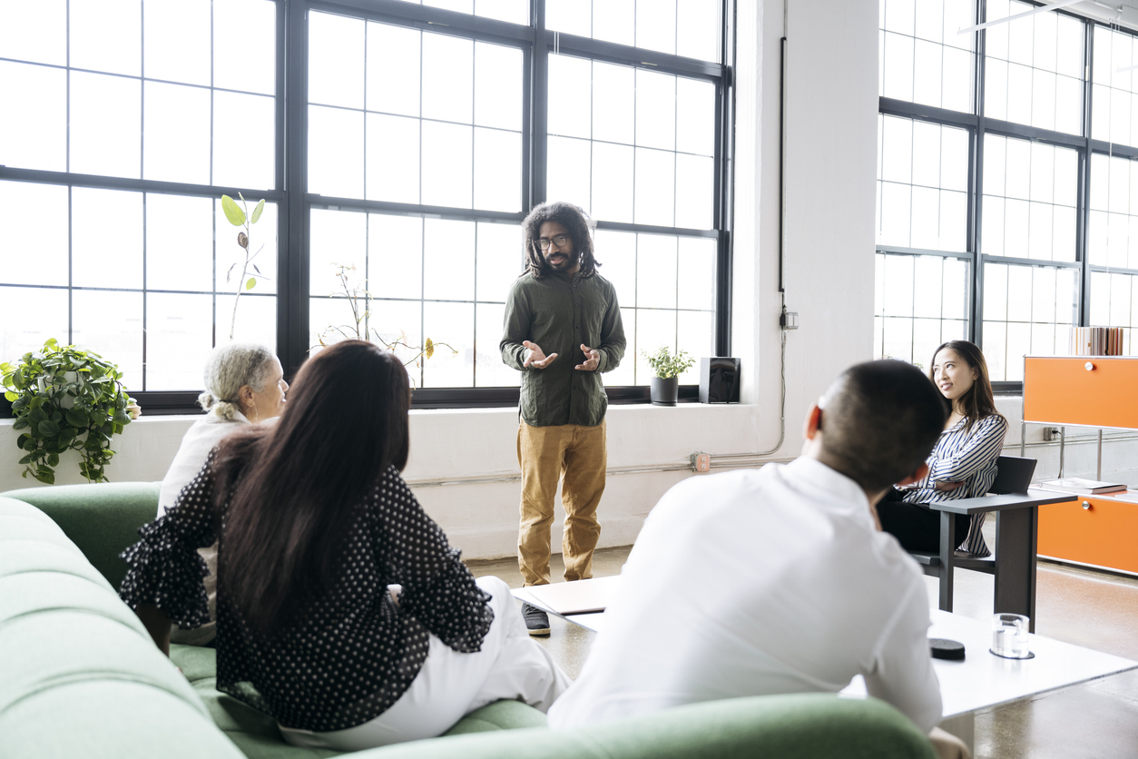 A creative director leads a meeting with a creative team.