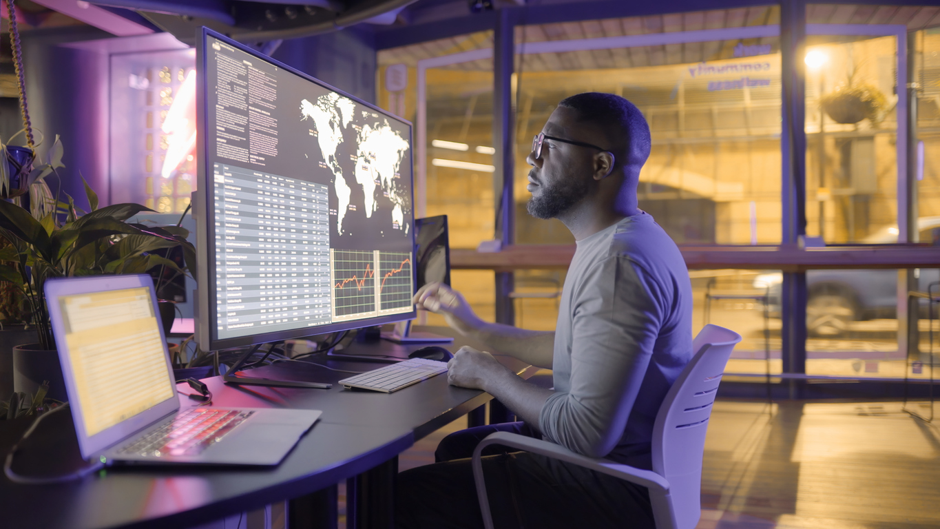 A Researcher Studies Global Crime Statistics on a Monitor.