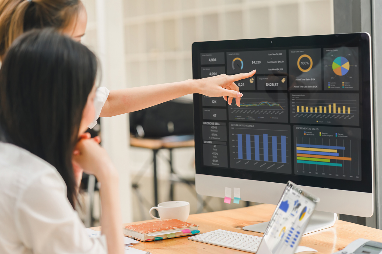 Two cybersecurity professionals looking and pointing at a monitor. 