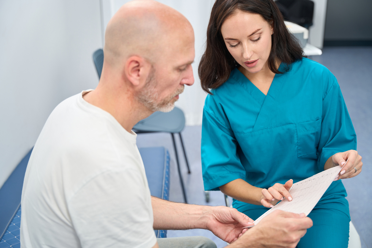 A Nurse Navigator Points to a Document While Explaining Its Contents to a Patient.
