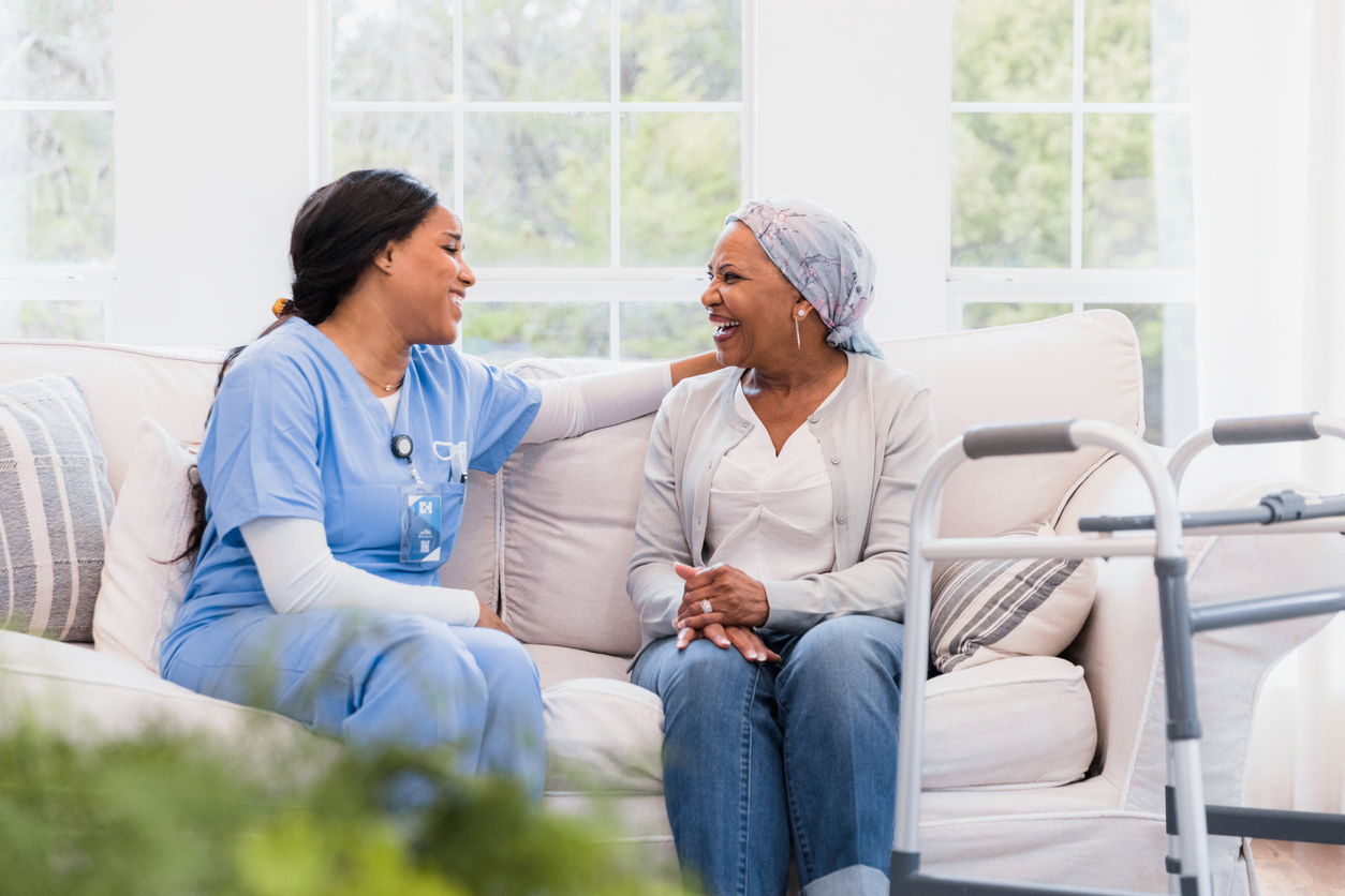 Hospice Nurse Sitting on a Couch With a Patient.