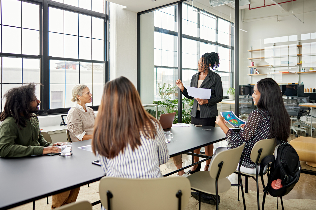 A project manager leads a meeting in a conference room.