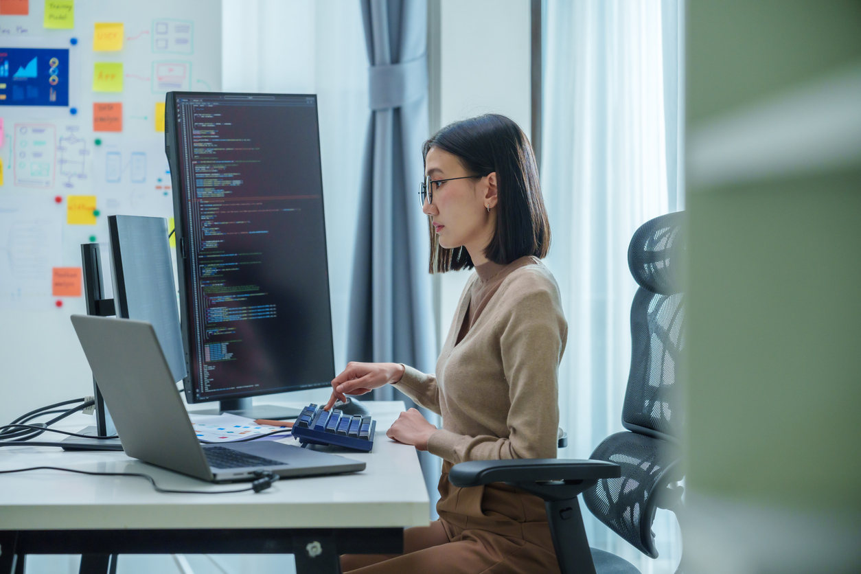 A blockchain developer working on a computer at a desk.