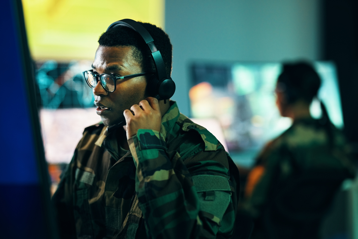 Defense Analyst at a Computer Wearing a Headset.