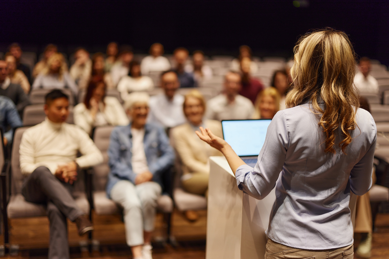 A public relations specialist at a podium gives a press conference.