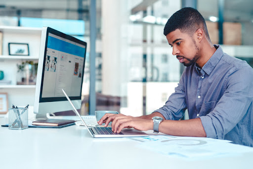  A content strategist in an office works on an article on a laptop.