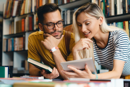 Two liberal arts students study in a college library.