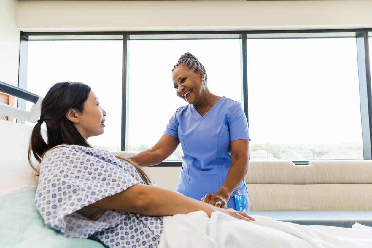 A Nurse Caring for a Patient in a Bed in a Medical Facility.