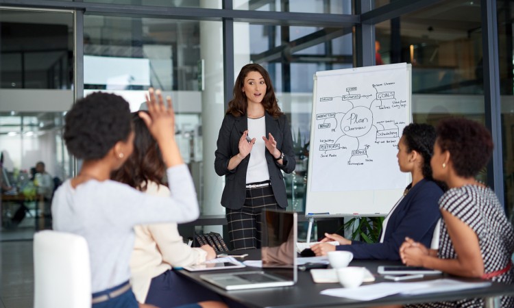 A person leading a marketing meeting in a boardroom