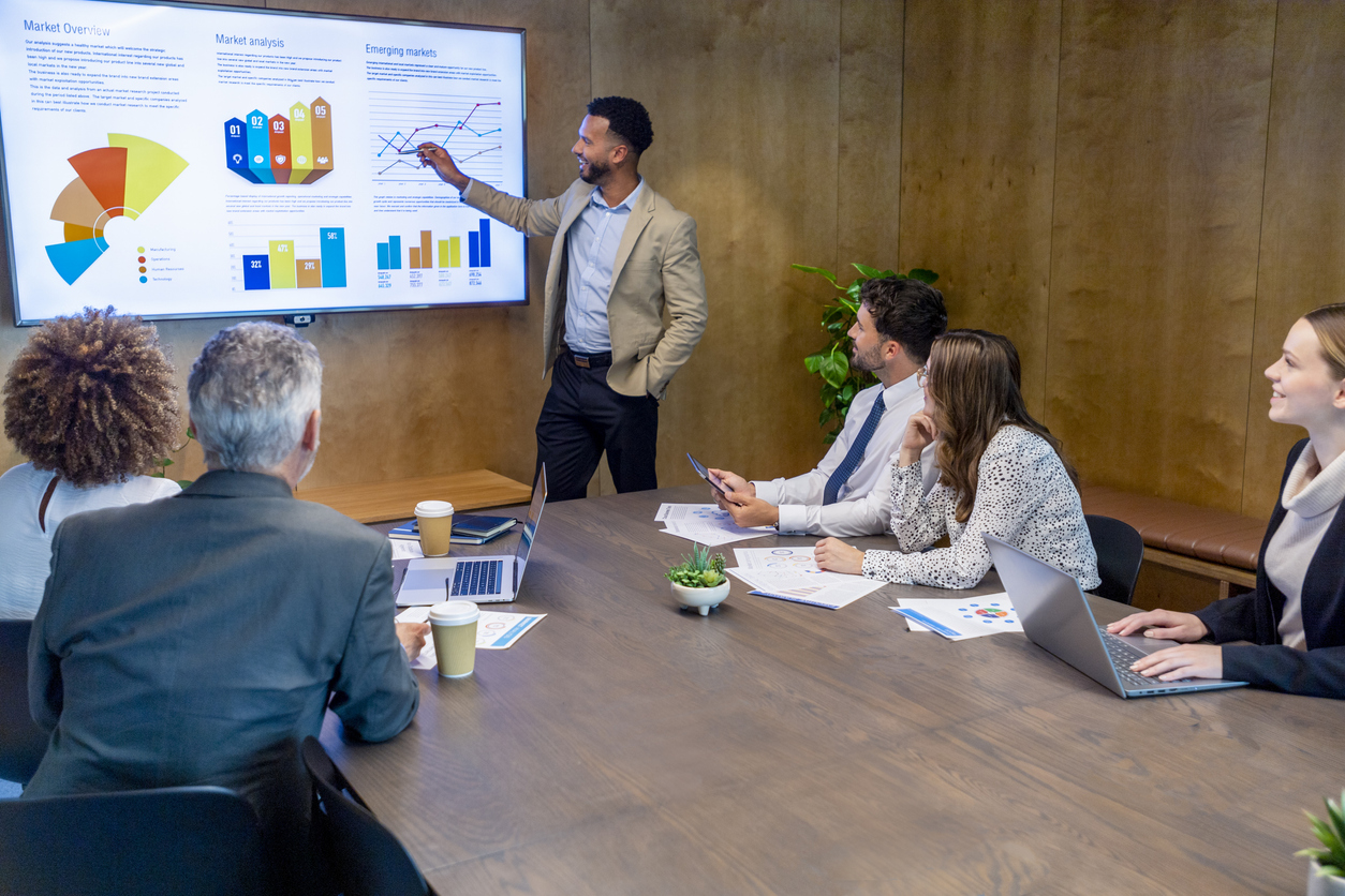 A Market Research Analyst Gives a Presentation in a Conference Room Using a Smart Board.