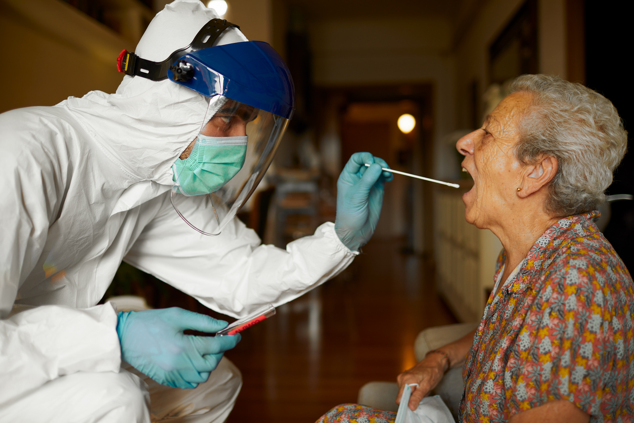 An Infection Control Practitioner in Full Protective Equipment Takes a Mouth Swab From a Patient.