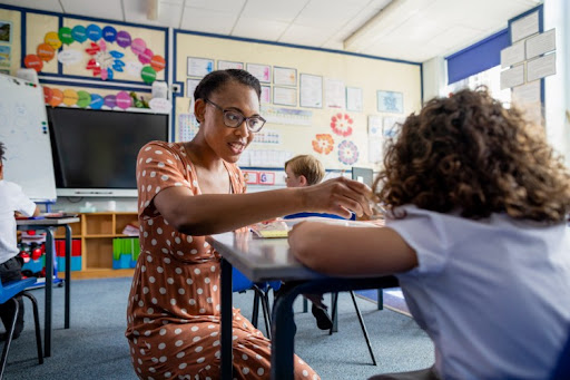 A teacher works one-on-one with a student.