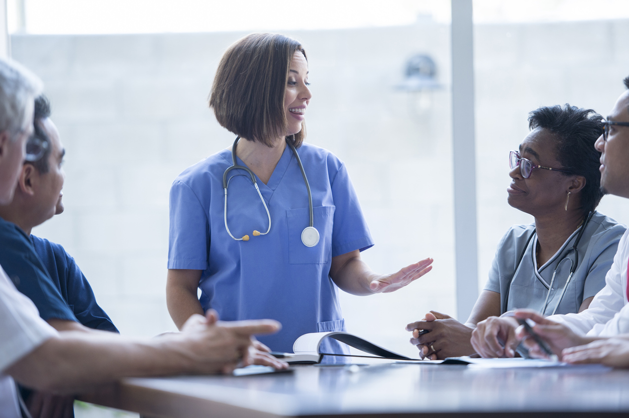 A Group of Smiling Nurses Gathered Around a Table.