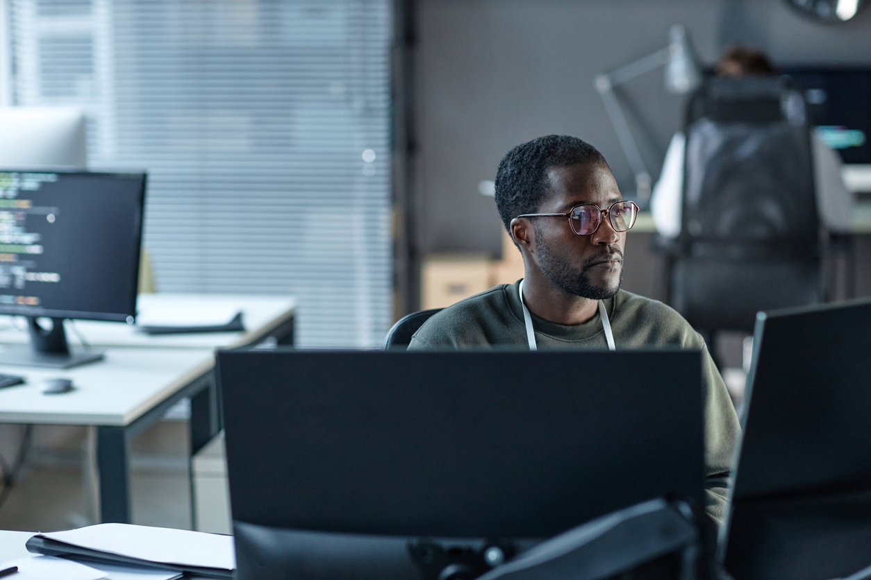 A cyber intelligence professional works on a computer.