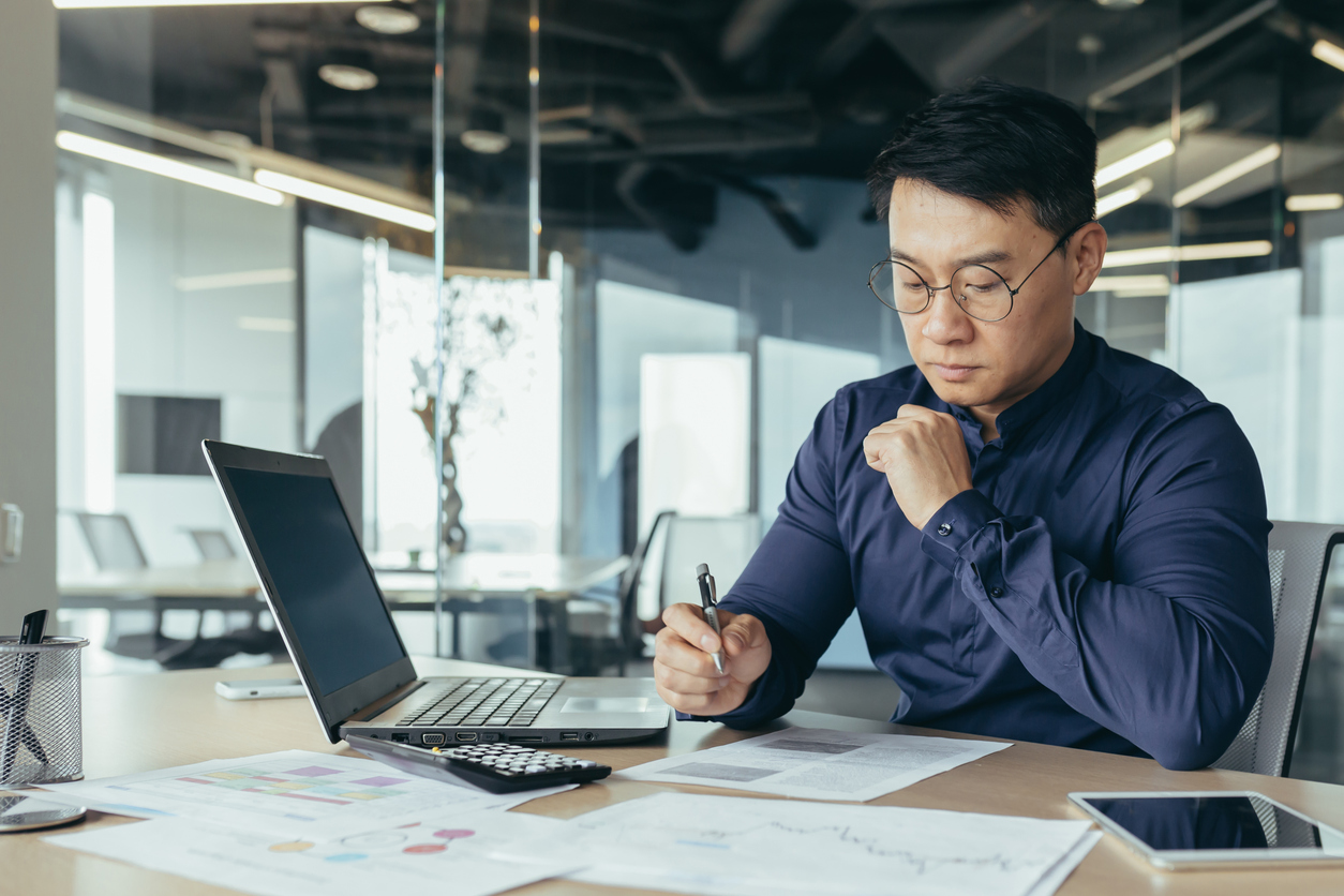 An Accountant Works With a Laptop and Calculator.