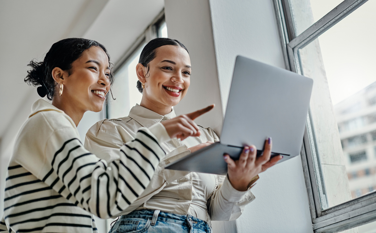 A brand ambassador and manager looking at a brand strategy at a laptop.