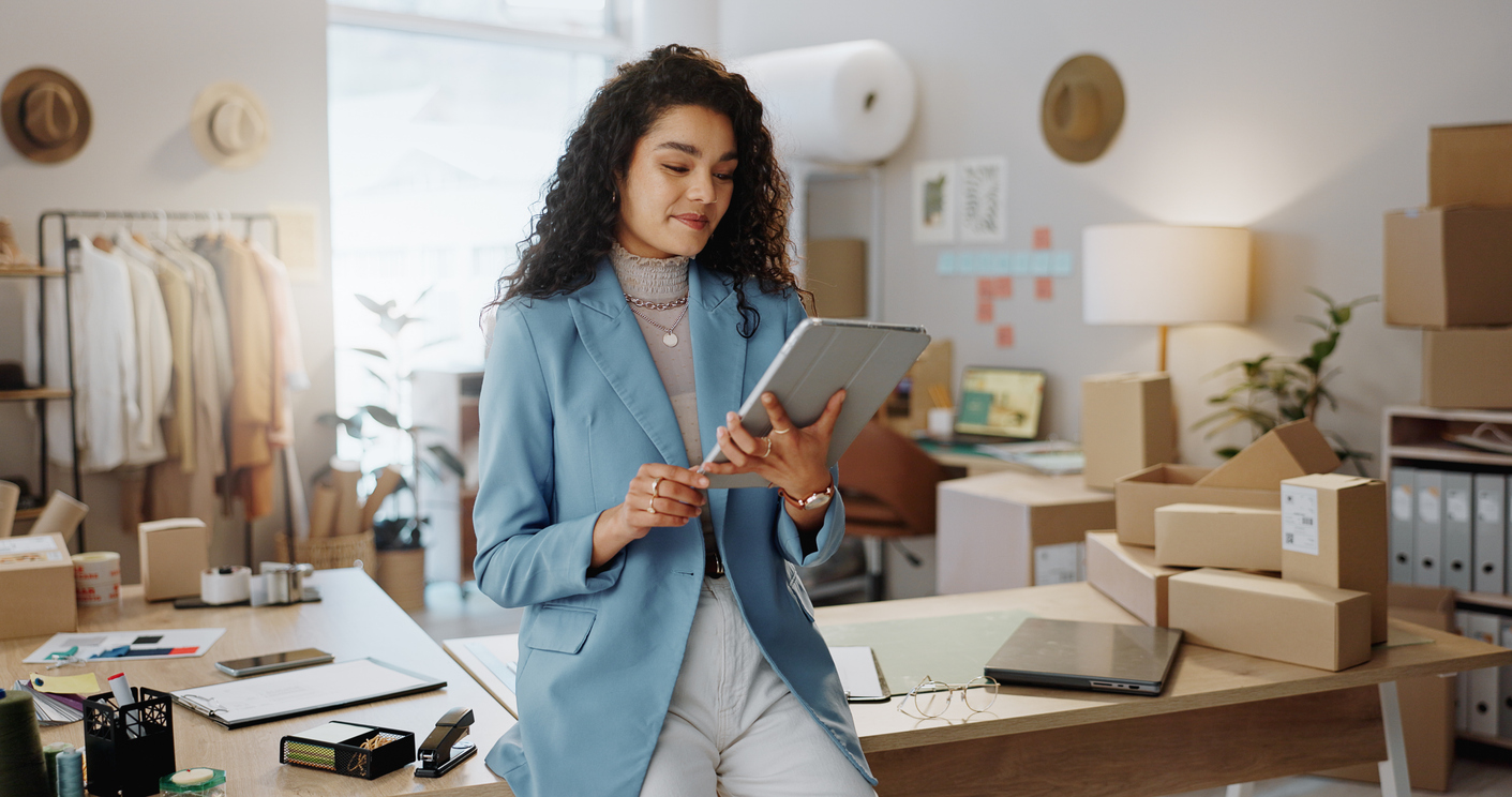 An Entrepreneur Holding a Tablet and Standing in an Office.