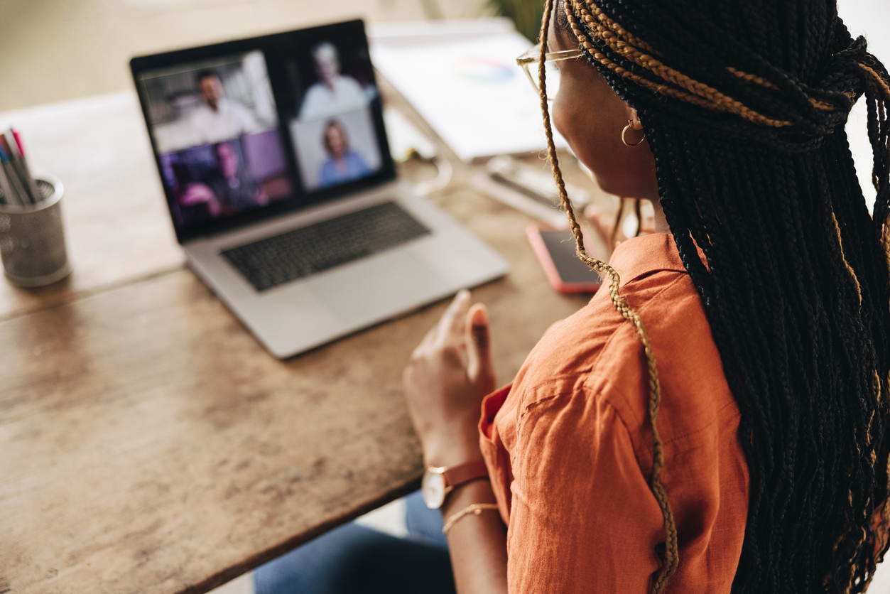 A consultant meets with clients via video call from a home office.