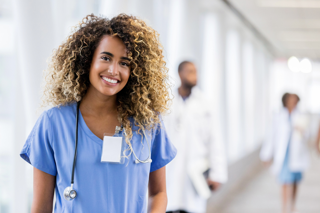 A Smiling Nurse in a Hospital Hallway.