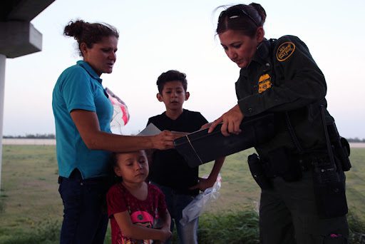  A U.S. Border Patrol officer works with a family seeking asylum at the Texas border.