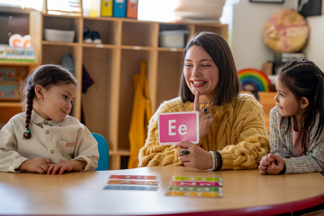 A Preschool Teacher Shows Students Alphabet Flash Cards.