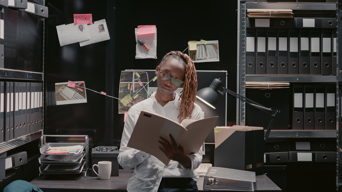 A criminal justice professional looking at files in an office. 