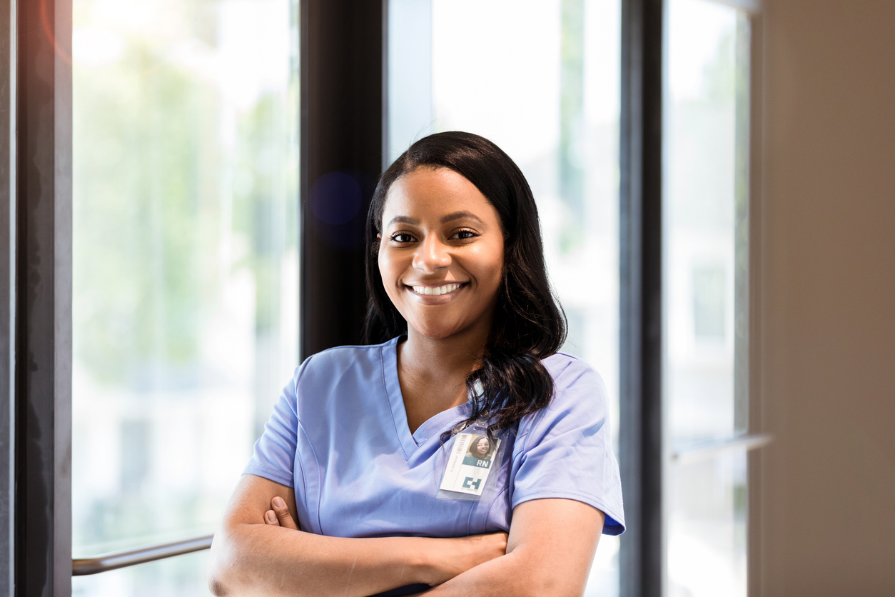 A Smiling Nurse Standing in a Hospital Corridor