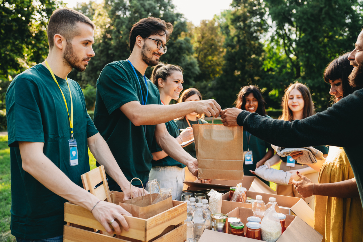 Volunteers handing out food and supplies in a park.