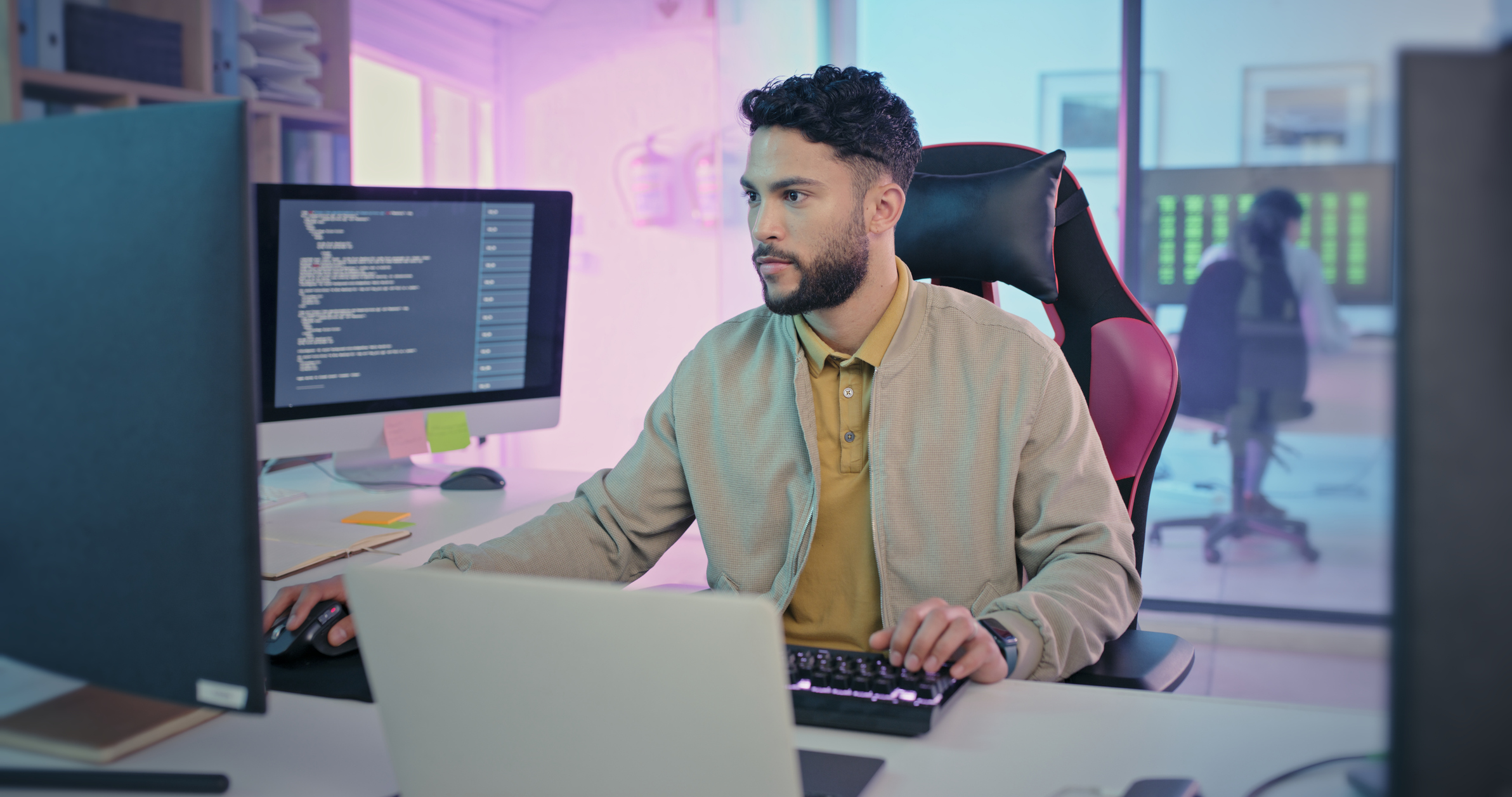 A cybersecurity professional working on multiple monitors.