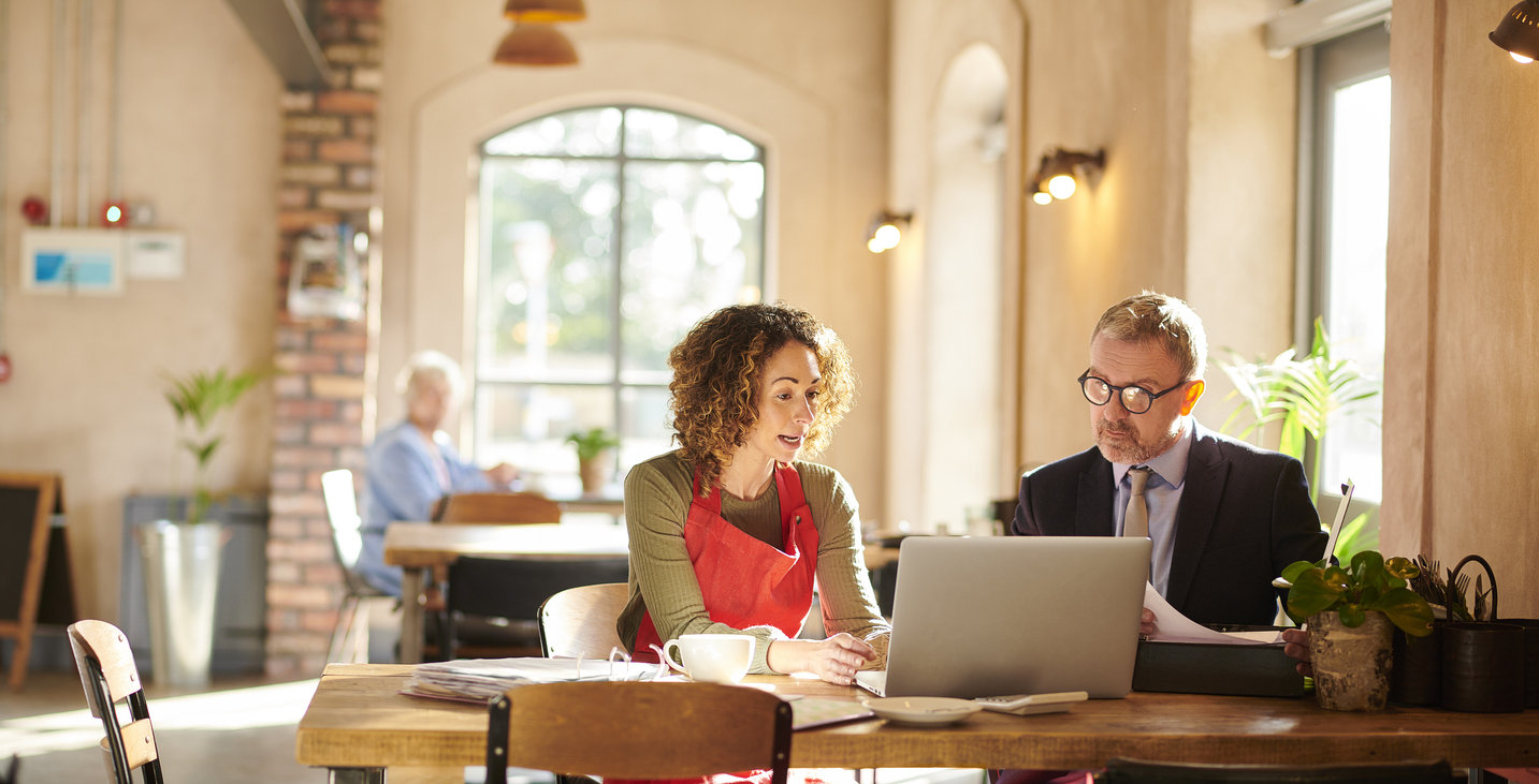 A business strategy consultant meets with a cafe owner.