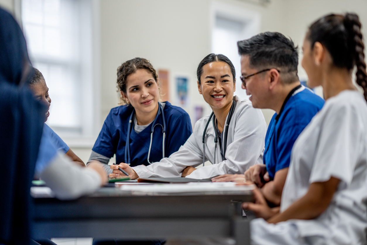 Nurses sitting and talking around a table.