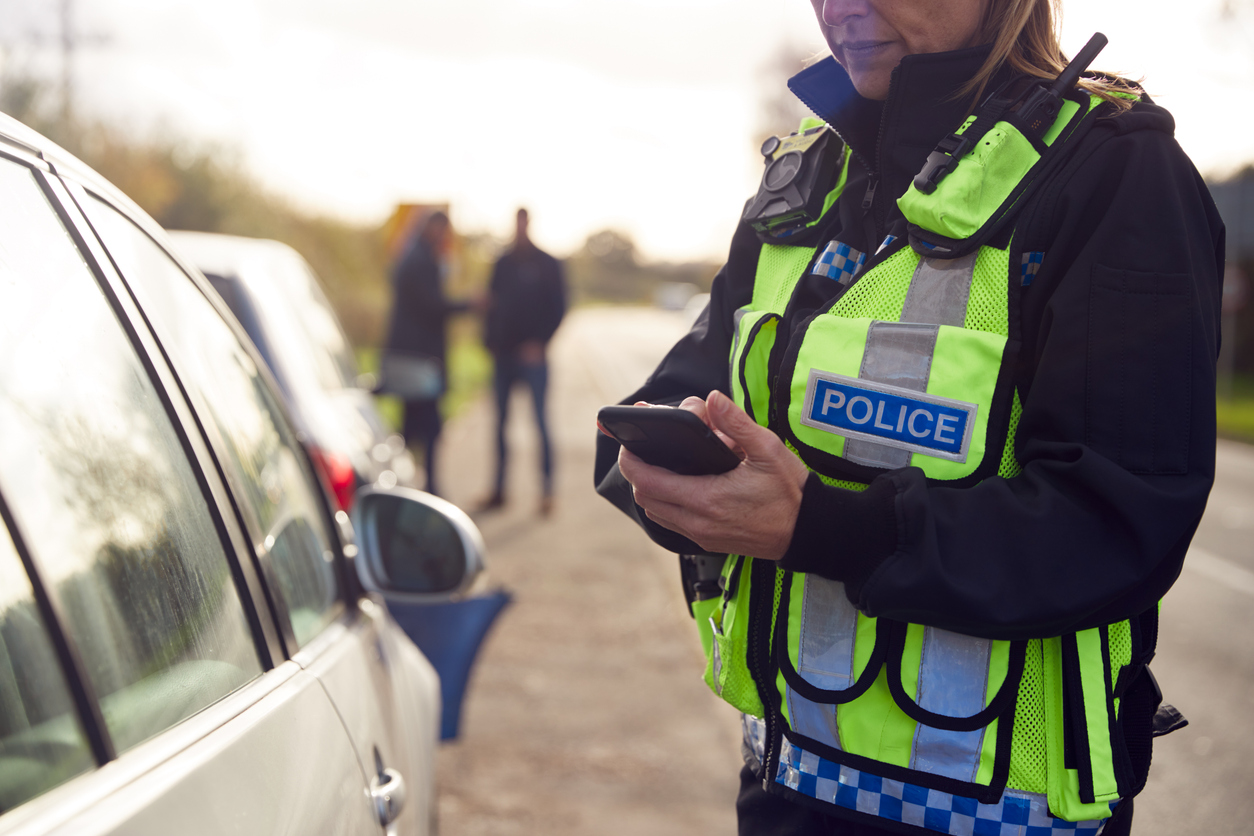 A Patrol Officer Records the Details of a Traffic Accident on a Mobile Device.