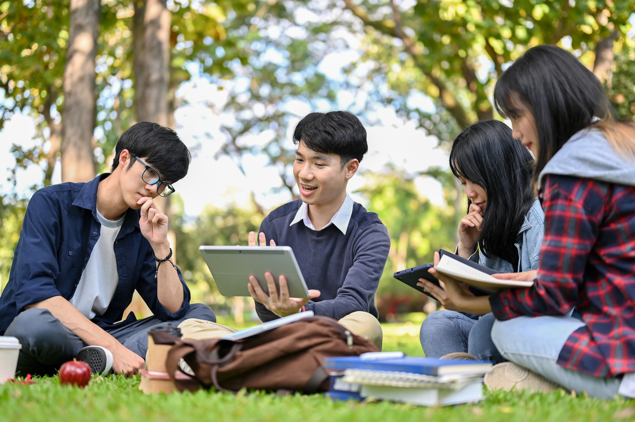 College students work on a project together in a campus park.