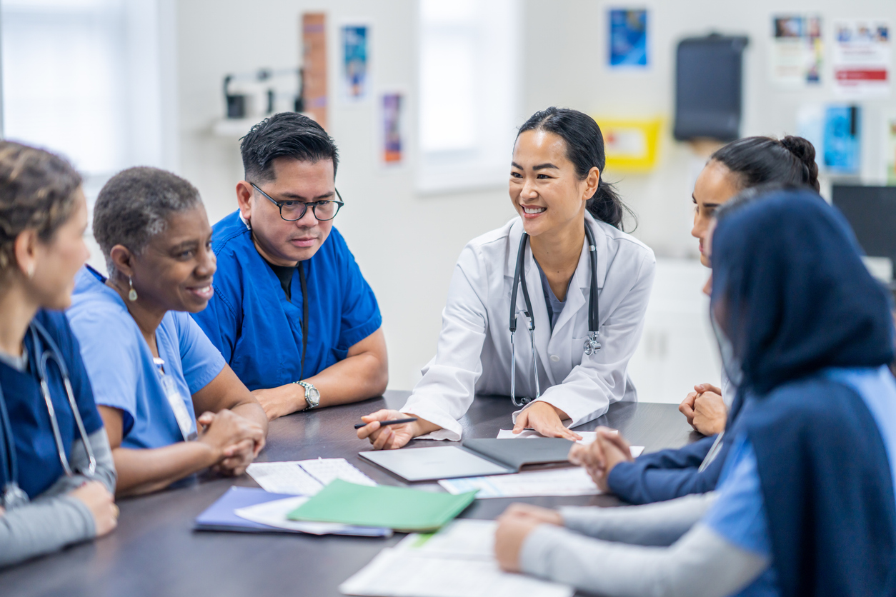 A group of nurses gathered around a conference table.