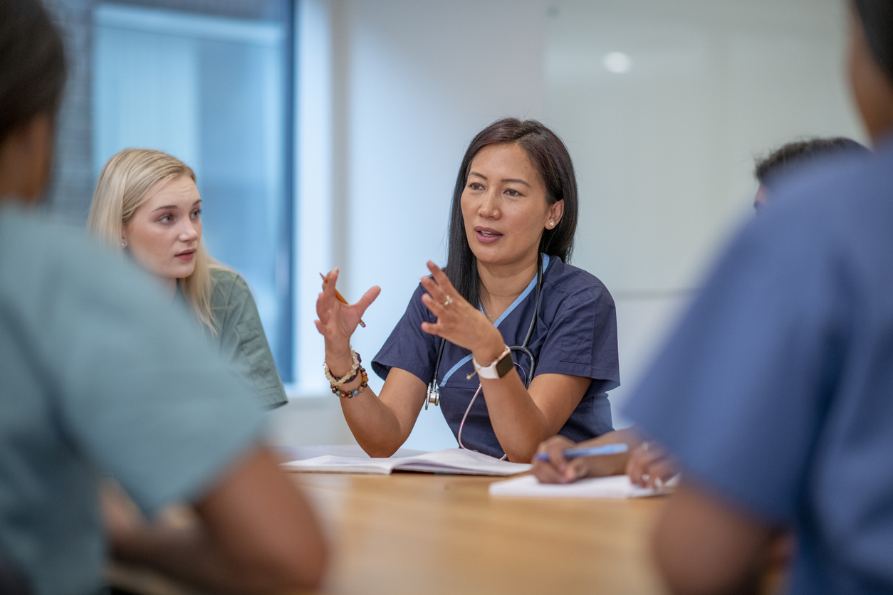 A Nurse Meeting With Other Professionals in a Conference Room.