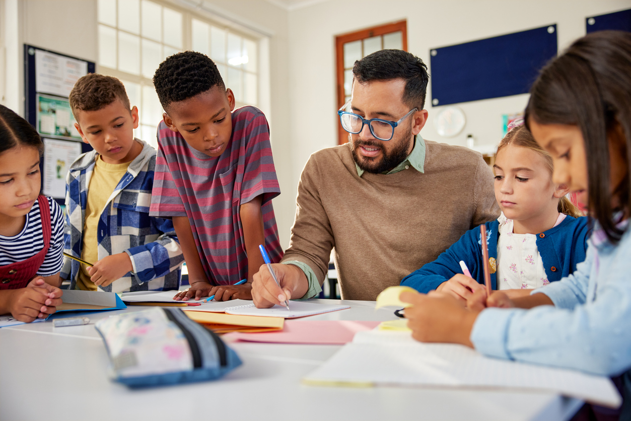 An Educator Works With a Group of Young Students in a Classroom.