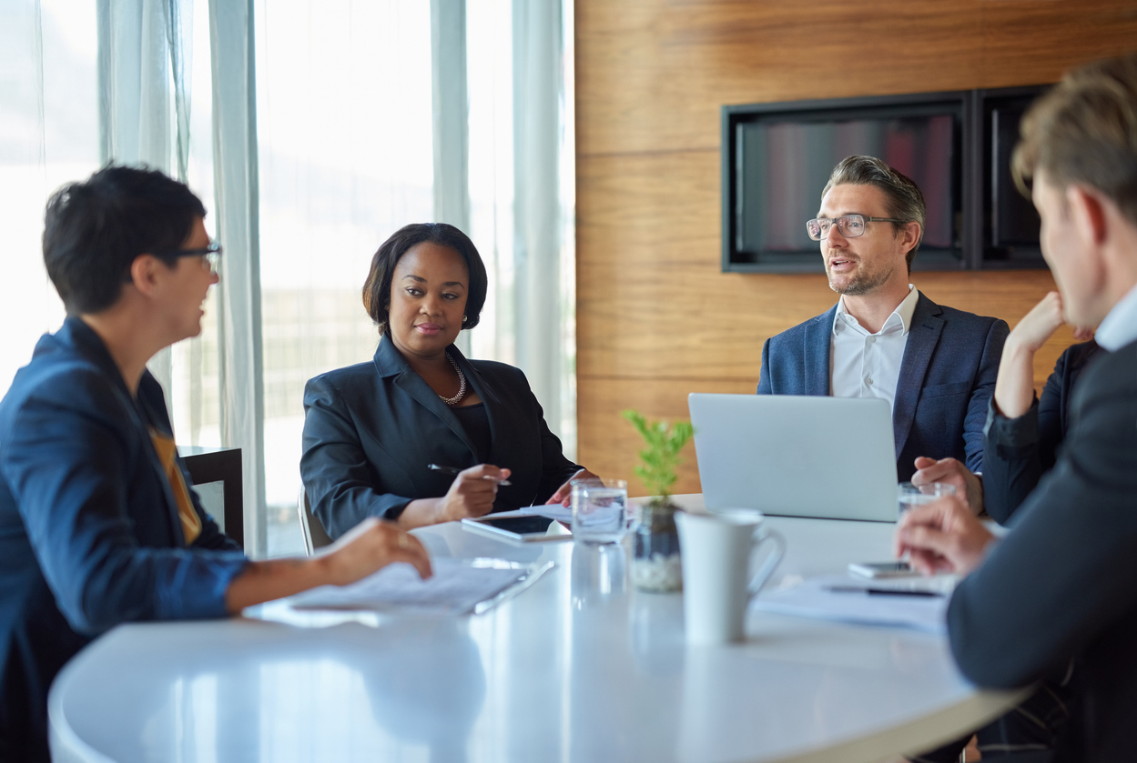 A Group of Coworkers Talking Around a Conference Table.